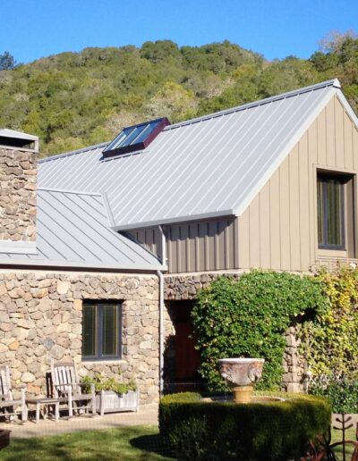 stone home with grey metal roof